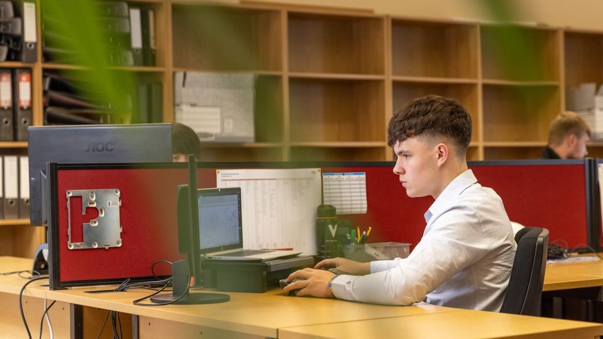 정부지원금 서류 온라인 제출 글 대표이미지 · 사진: A focused young man typing on a computer in a contemporary office environment.