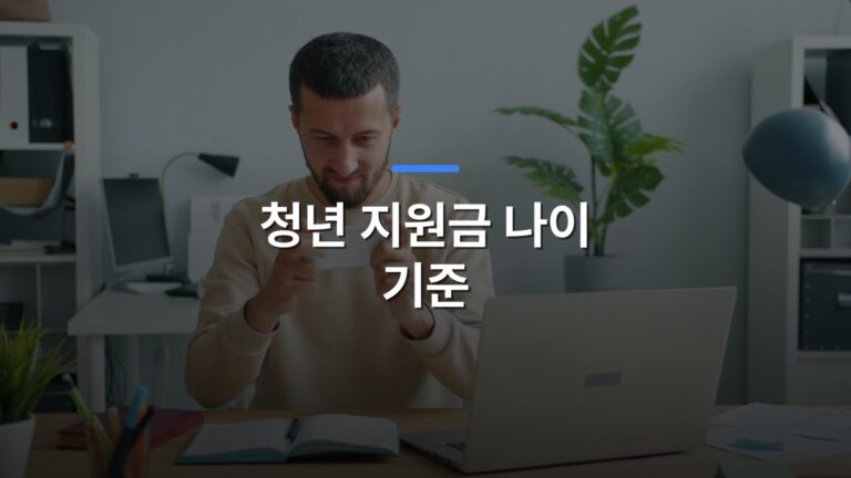 청년 지원금 나이 기준 글 대표이미지 · 배경 사진: Focused man using smartphone at a desk with laptop in a modern office setting.